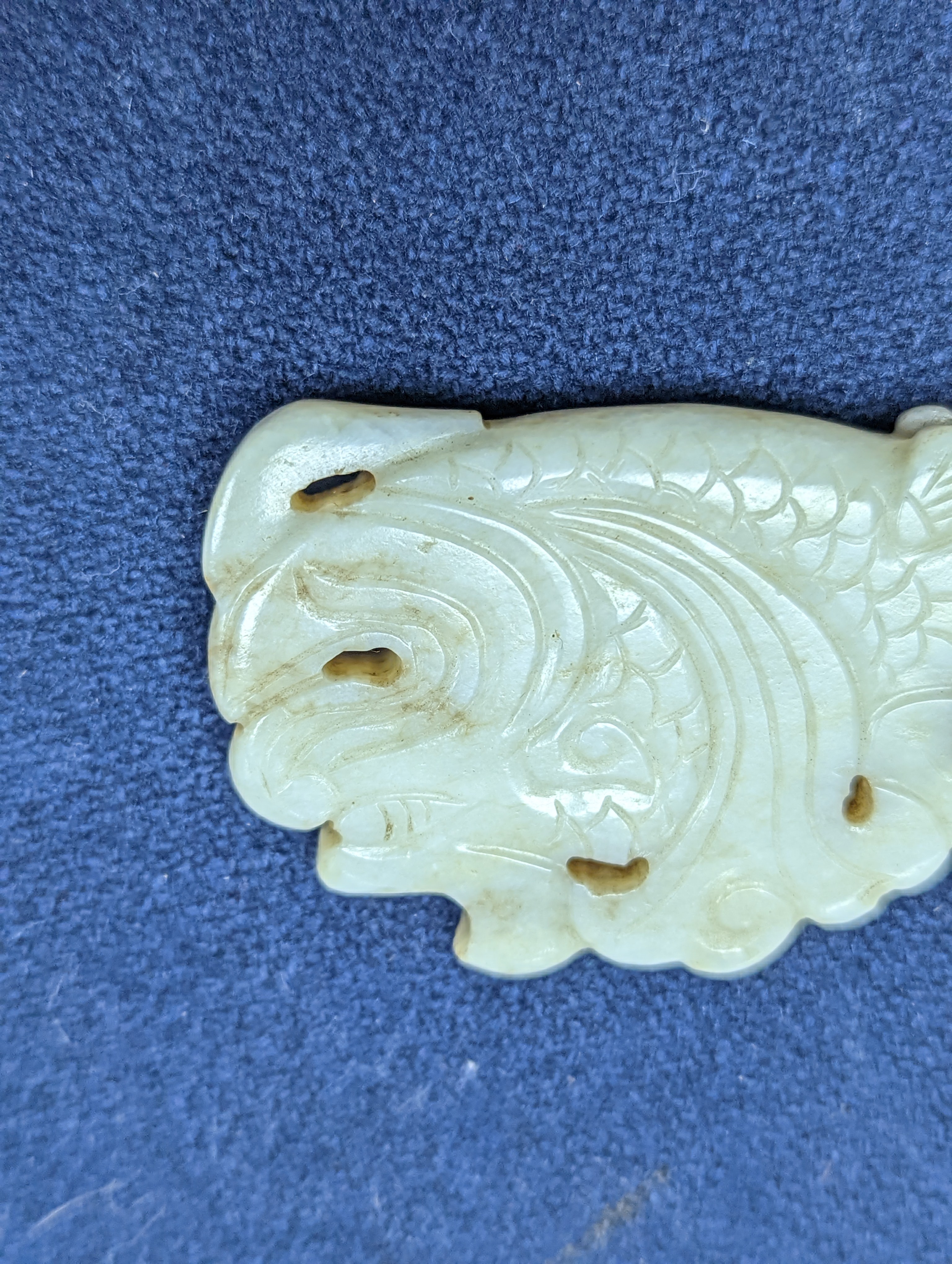 A Chinese white and black jade ‘dragon-fish’ plaque, 19th/20th century, 6cm